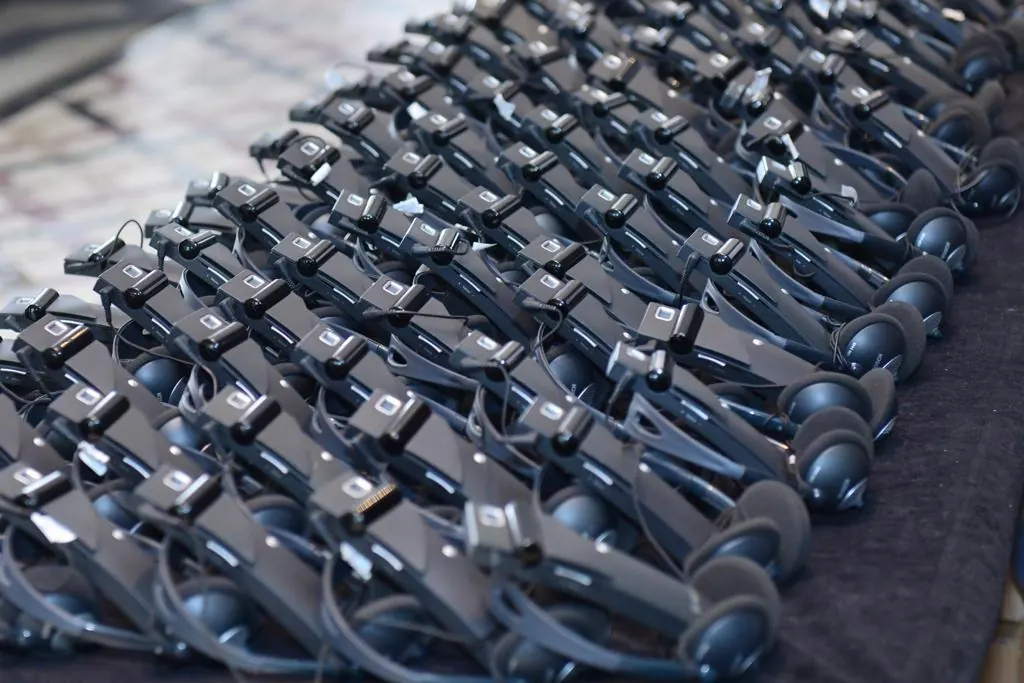 Récepteurs et casques d’interprétation simultanée alignés sur une table, matériel de conférence