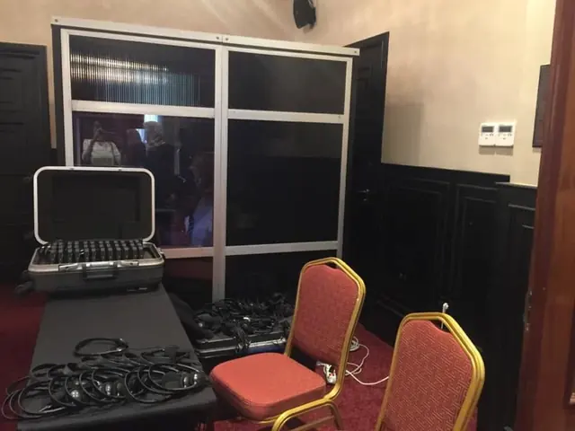 Valise de récepteurs, casques et cabine d’interprétation installés dans une salle de réunion