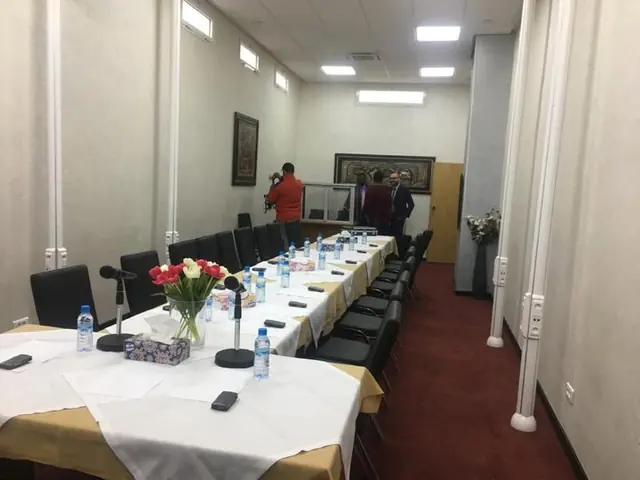 Longue table de réunion équipée de microphones de conférence