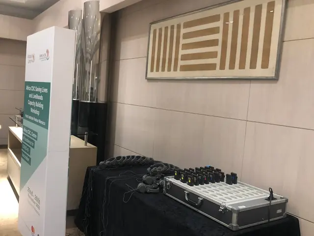 Valise de récepteurs d’interprétation et casques posés sur une table, prêts pour les participants